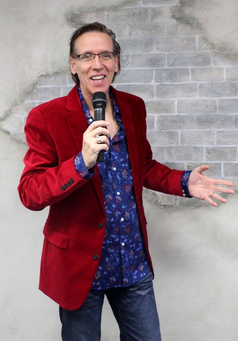 Eric Thompson commands the stage with his signature charm and energy, microphone in hand as he delivers what's clearly a crowd-pleasing moment during his 2023 performance.