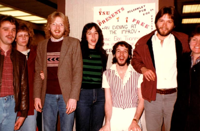 Eric Thompson shares a laugh with friends at what appears to be a comedy club event in 1984, showcasing the casual camaraderie that made him such a beloved performer in the entertainment scene.