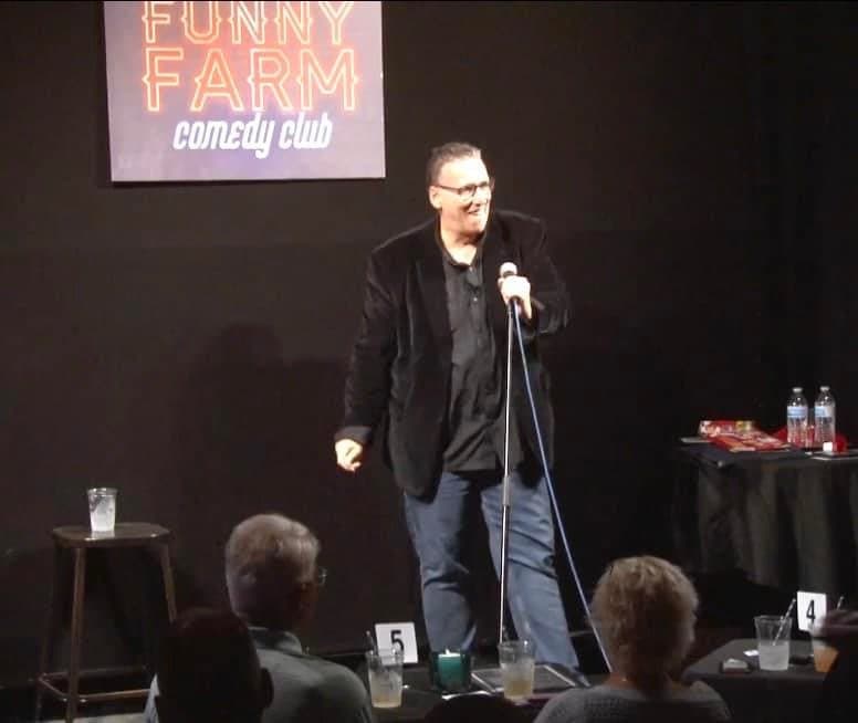 Eric Thompson commands the stage at the Funny Farm comedy club, delivering his signature blend of humor to an intimate audience of comedy lovers.