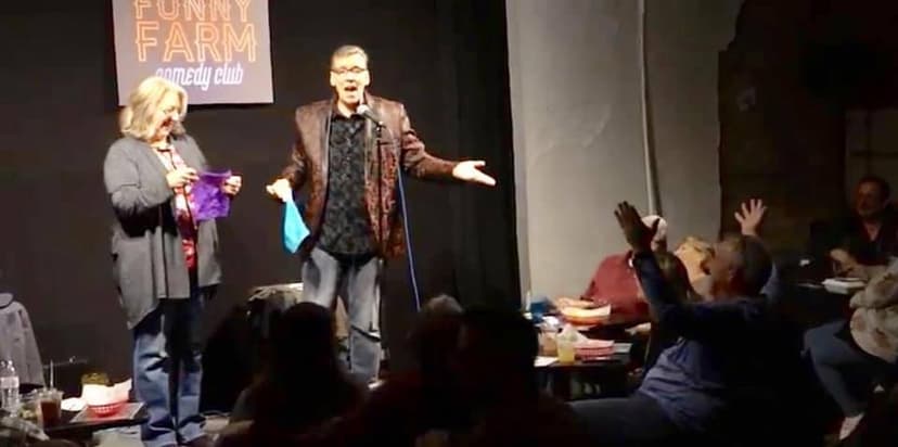 Eric Thompson engages the enthusiastic crowd at the Funny Farm comedy club, working his magic with audience participation as hands shoot up from every table.