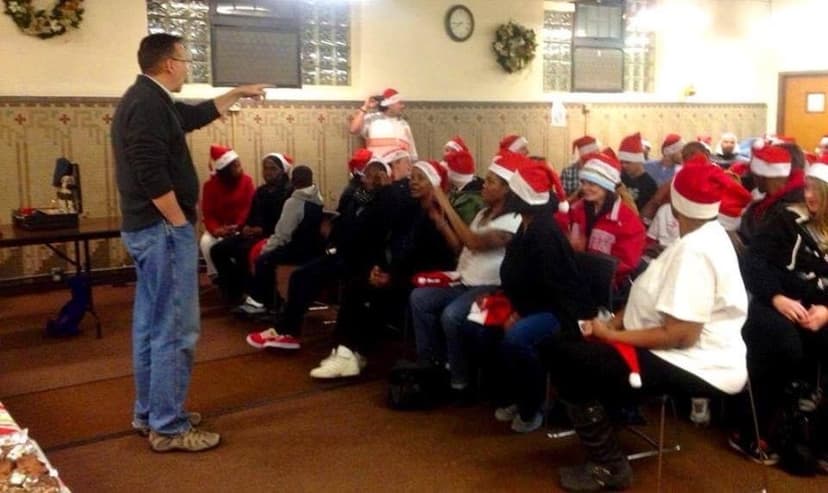Eric Thompson brings holiday cheer to a captivated audience, all sporting festive Santa hats as he delivers what's sure to be a memorable Christmas performance.