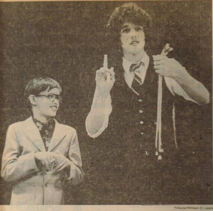 Eric Thompson captivates his audience during what appears to be a classic magic performance, with a young volunteer looking on in amazement as Eric demonstrates his signature showmanship and theatrical flair.