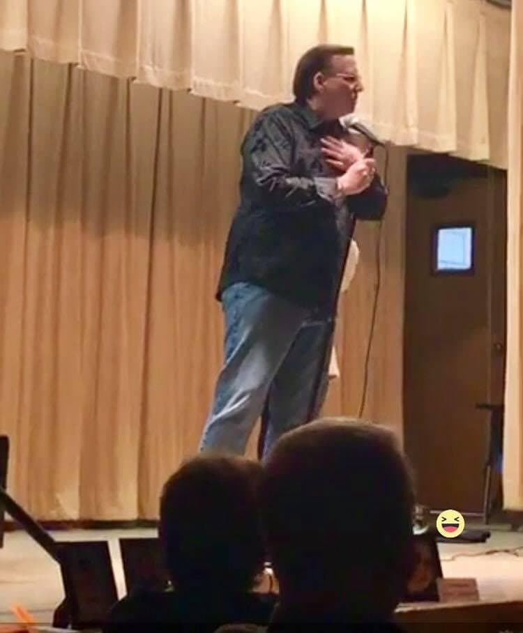Eric Thompson commands the stage with animated gestures and infectious energy, working his magic on a captivated audience from behind the microphone.