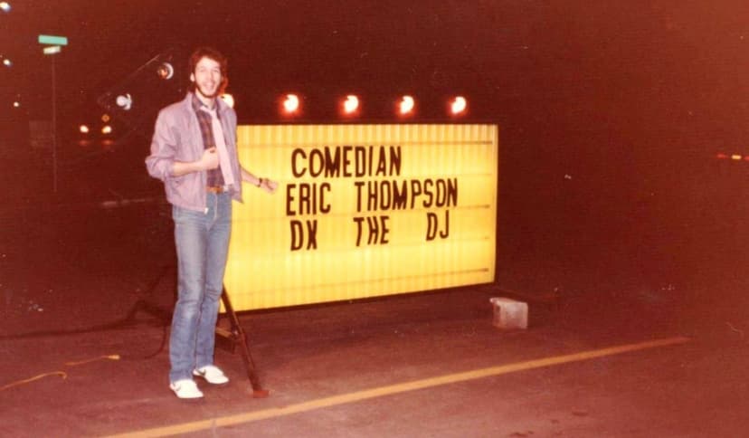 Eric Thompson strikes a pose next to the marquee sign announcing his comedy and DJ performance, showcasing the versatile entertainer's dual talents in one memorable night.