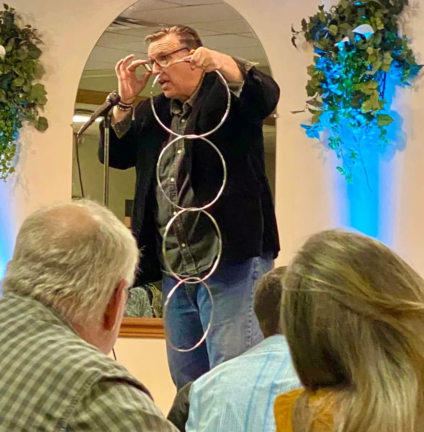 Eric Thompson captivates his audience with an impressive linking rings routine, demonstrating the classic magic that has made him a favorite at venues across the country for decades.
