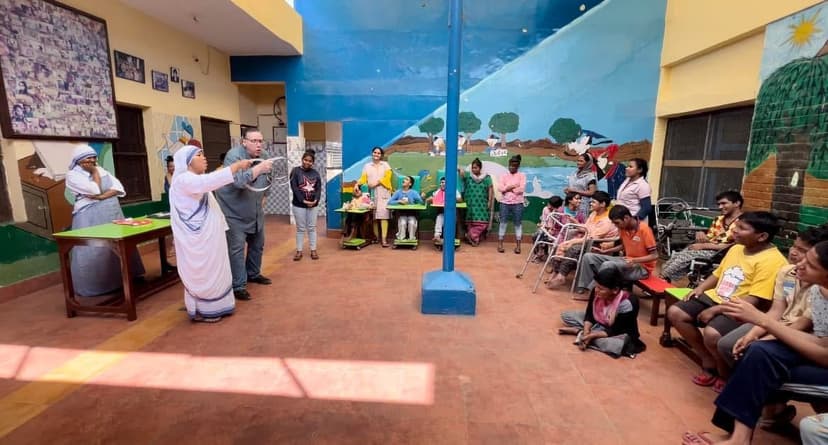 Eric Thompson captivates a diverse audience of children and adults in what appears to be a colorful community center or school setting, with his engaging performance bringing smiles to faces both young and old.
