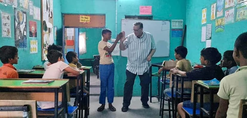 Eric Thompson brings his magic and comedy to a classroom full of delighted students, sharing a special moment with one young participant as the rest of the class watches in anticipation.