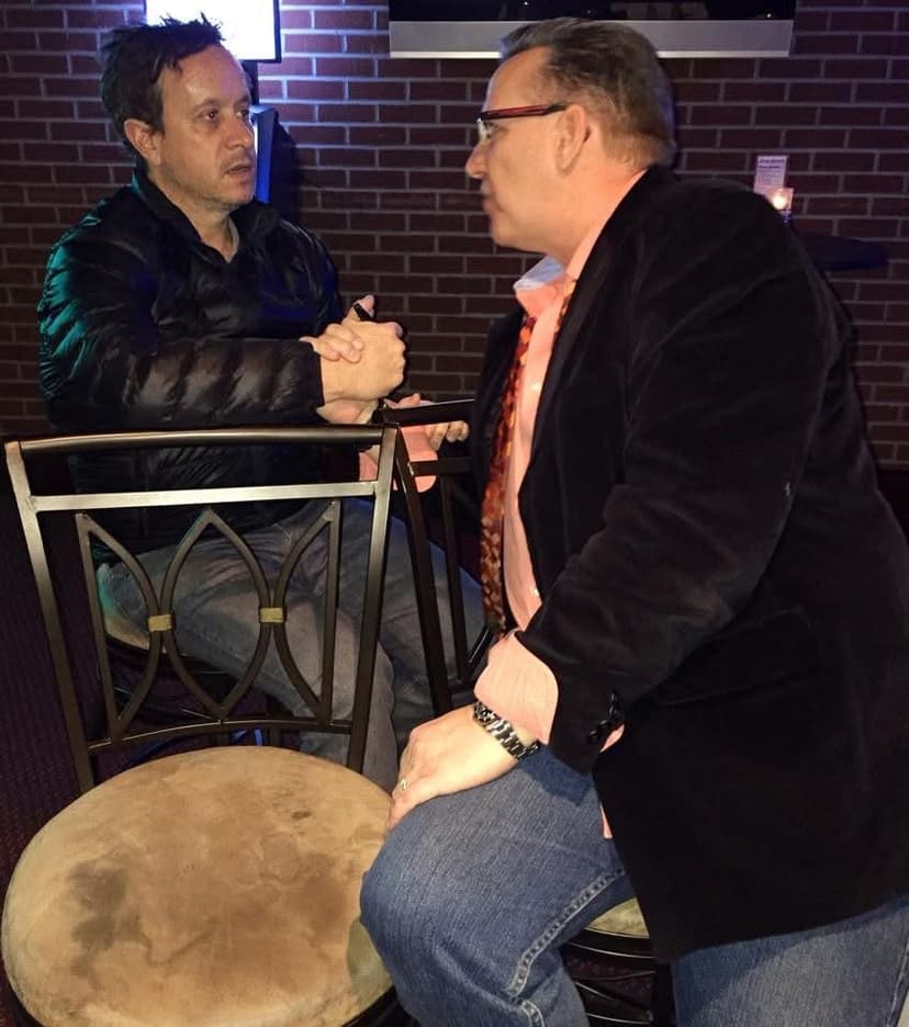 Eric Thompson enjoys an intimate conversation during what appears to be a meet and greet, connecting with audience members in his signature warm and engaging style.
