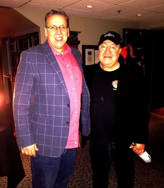 Eric Thompson poses backstage with a fellow entertainer, sharing a moment between shows at what appears to be a comedy venue or entertainment establishment.