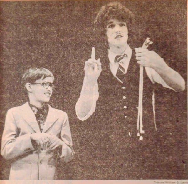 Eric Thompson shares the stage with a young performer, demonstrating his knack for connecting with audiences of all ages during what appears to be a classic comedy routine.