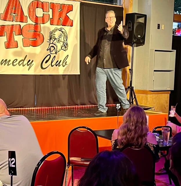 Eric Thompson commands the stage at Wack Tats Comedy Club, working his magic with the intimate crowd as audience members settle in with their drinks for what's sure to be a memorable evening of laughs.