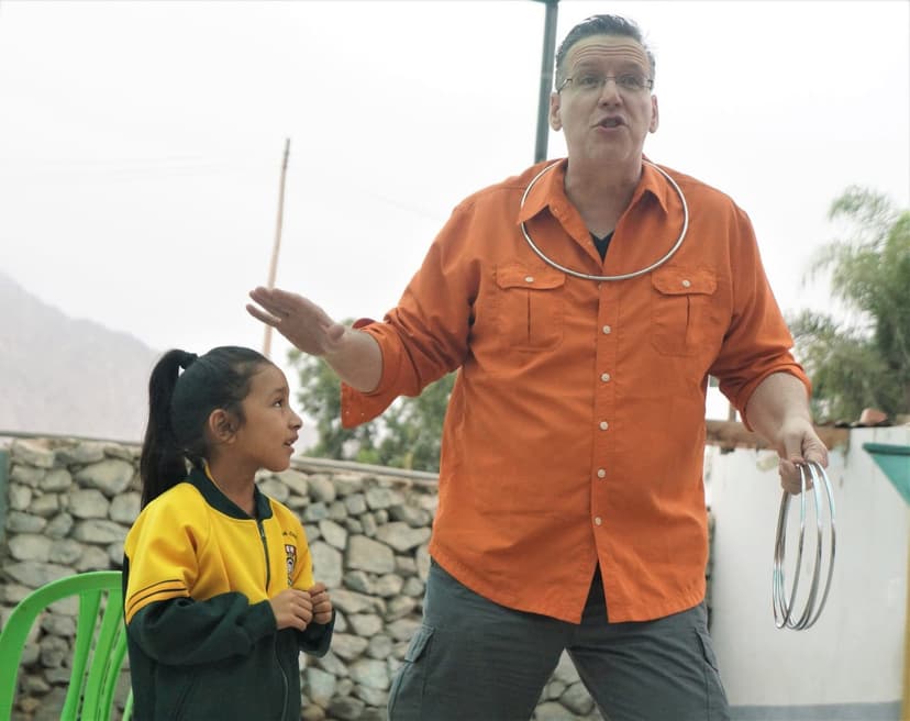 Eric Thompson captivates a young audience member during what appears to be an outdoor magic demonstration, showcasing his natural ability to connect with fans of all ages.