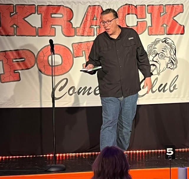 Eric Thompson commands the stage at the Krack Pot Comedy Club, delivering his signature blend of humor and charm to an appreciative audience.