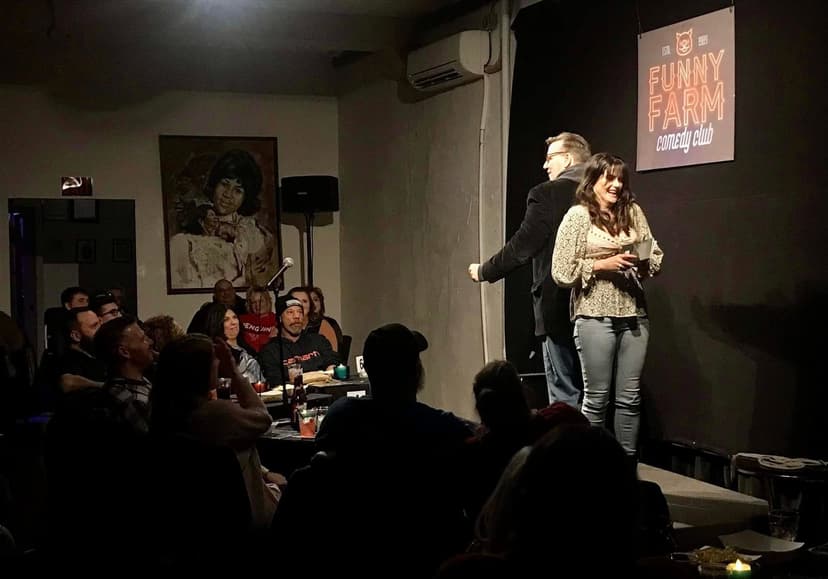 Eric Thompson brings a lucky audience member on stage for what promises to be a memorable interactive moment at the intimate Funny Farm Comedy Club, where the cozy atmosphere perfectly showcases his engaging performance style.