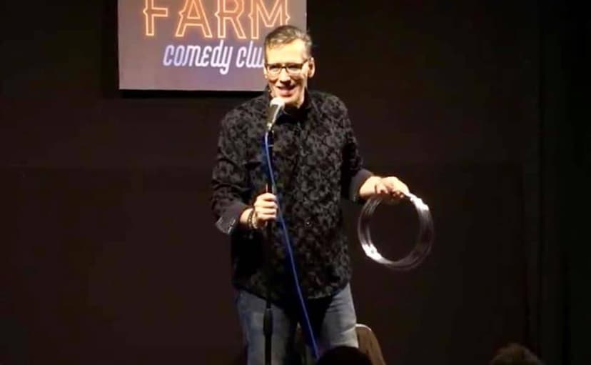 Eric Thompson delights the crowd at the Farm Comedy Club, wielding what appears to be a mixing bowl as part of his signature blend of comedy and magic that keeps audiences laughing nationwide.