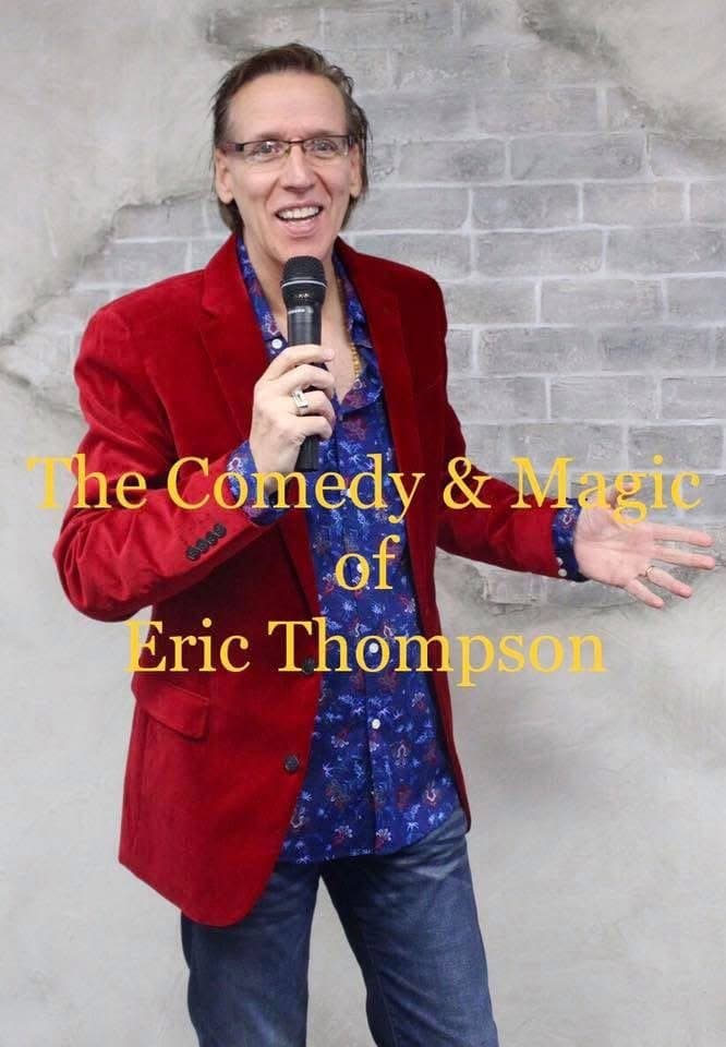 Eric Thompson strikes a classic entertainer's pose with microphone in hand, his signature red blazer and warm smile ready to charm another audience with his unique blend of comedy and magic.