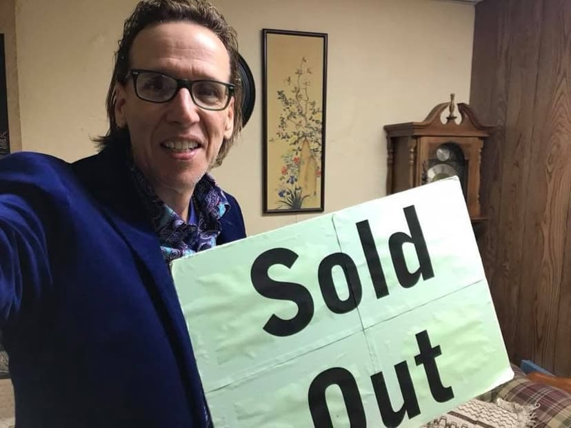 Eric Thompson celebrates another successful show with his signature 'Sold Out' sign, flashing that winning smile that's been packing venues since the 1980s. The entertainer's obvious joy at connecting with audiences shines through in this triumphant backstage moment.