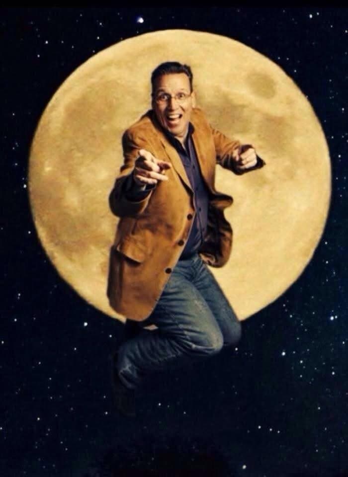 Eric Thompson strikes a dynamic pose against a starry backdrop with a full moon, showcasing the theatrical flair that has made him a beloved entertainer for decades.