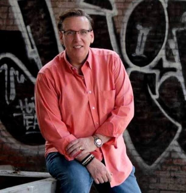 Eric Thompson strikes a confident pose during what appears to be a professional photo shoot, his warm smile and relaxed demeanor showcasing the charismatic personality that has made him a favorite entertainer for over four decades.