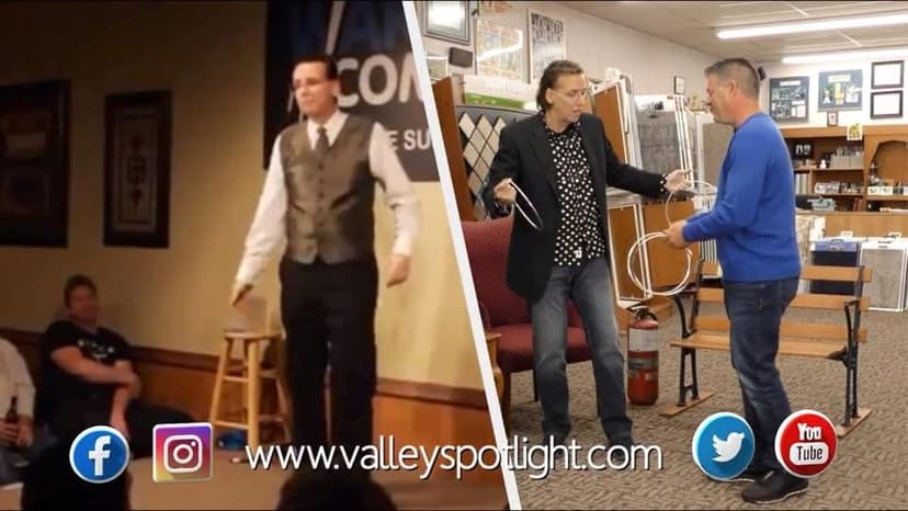 Eric Thompson captivates his audience during what appears to be a library or community center performance, showcasing his signature blend of comedy and magic that has delighted crowds for decades.